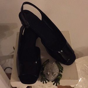 Peep toes black patent leather wedges.